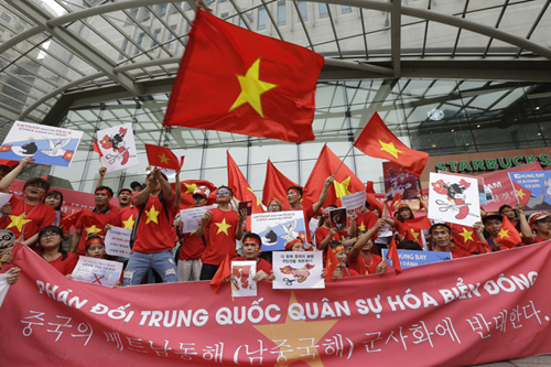 Vietnamese protesters hold their national flags, anti-China placards and a banner that reads: ‘We oppose China because they escalate tensions on the waters of the South China Sea’ during a rally against China near the Chinese embassy in Seoul, South Korea, Sunday (AP photo)